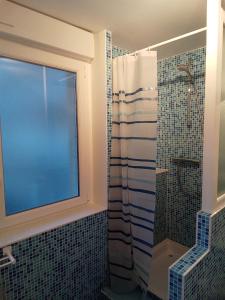 een badkamer met een douche en een raam bij Côté Mer in Barneville-Carteret