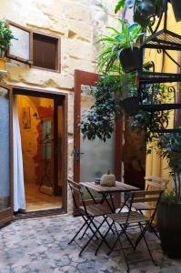 un patio con tavolo e sedie di fronte a un edificio di Fusion Homestay Accommodation a Mosta