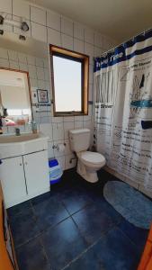 a bathroom with a toilet and a sink and a window at Casa en Farellones in Santiago