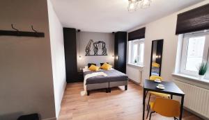 ein Schlafzimmer mit einem Bett mit gelben Kissen und einem Tisch in der Unterkunft GRYF Apartamenty Holiday Family in Stettin