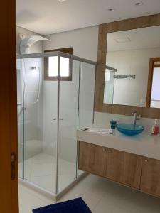 a bathroom with a glass shower and a sink at CASA Beira Mar Pé na Areia - Itacimirim Bahia in Camaçari