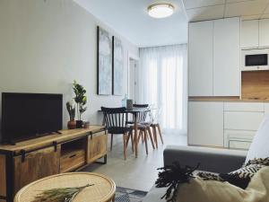 uma sala de estar com um sofá, uma televisão e uma mesa em Apartamentos Martalia Namar centro em Ronda