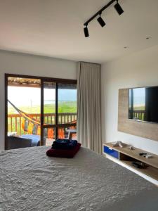 a bedroom with a large bed and a television at CASA Beira Mar Pé na Areia - Itacimirim Bahia in Camaçari +70 photos