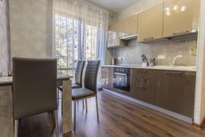 a kitchen with a table and chairs and a sink at Vidnyi ApartHotel in Adler