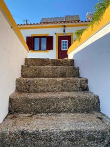 un conjunto de escaleras que conducen a una casa con una puerta roja en Lugar d´vagar, Vale Serrão, Castelo de Vide, en Castelo de Vide
