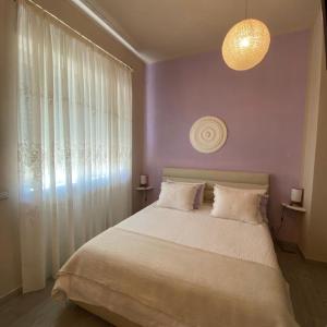 - une chambre avec un grand lit et un mur violet dans l'établissement Cascina Beatrice Az Agrituristica, à Rodello
