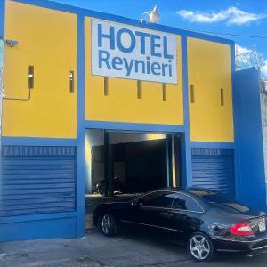a car parked inside of a hotel repair garage at Hotel Reynieri in Comayagüela