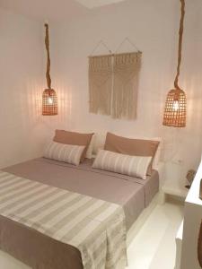 un letto in una camera bianca con due luci di Amalthea Guest House a Città di Kos