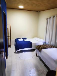 a bedroom with two beds in a room at Pousada do Sol in Alto Paraíso de Goiás