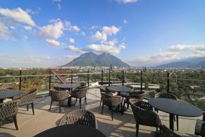 a patio with tables and chairs and a view of a mountain at Holiday Inn Express - Monterrey - Fundidora, an IHG Hotel in Monterrey