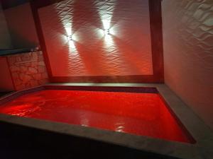 bañera roja con líquido rojo en DISPONIVEL NATAL E REVEILLON - Casa Linda e Aconchegante com Piscina -Aquecimento Solar o Ano Todo Perto da Praia, en Praia Grande
