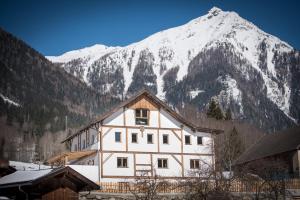 a building in front of a snow covered mountain at Gletscher Appartements in Flattach