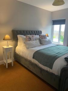 Un dormitorio con una cama grande y una ventana en The moorings, en Belmullet