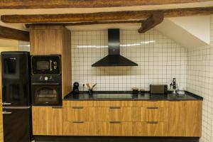 cocina con nevera negra y fogones en Casa rural Can Miralter, en Camprodon