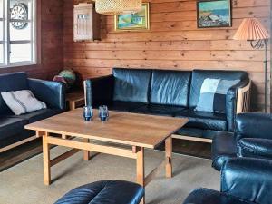 a living room with a leather couch and a table at 6 person holiday home in R m in Lakolk