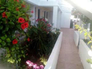 a balcony with red flowers and a walkway at Villas Irene 3 Family Apartments in Gournes
