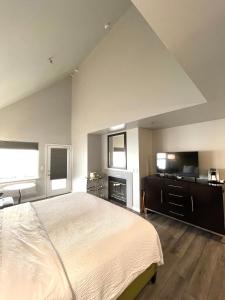 ein großes Schlafzimmer mit einem großen Bett und einem Kamin in der Unterkunft Tides Inn & Suites in Port Townsend