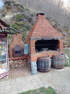 a brick oven with two barrels in front of it at Kapija Dragačeva apartmani in Ovčar Banja
