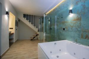 y baño con ducha de cristal y bañera blanca. en Azahara Casa Boutique, en Arcos de la Frontera
