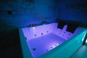 a bath tub with a blue light in a bathroom at Azahara Casa Boutique in Arcos de la Frontera