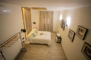 1 dormitorio con cama blanca y espejo en Azahara Casa Boutique en Arcos de la Frontera