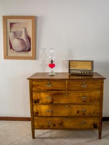 eine hölzerne Kommode mit einem Glas Wein darüber in der Unterkunft Maré Alta - Casa de Férias in Maia