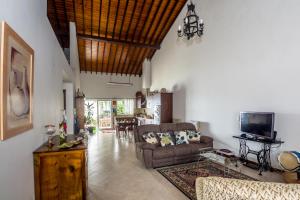 ein Wohnzimmer mit einem Sofa und einem TV in der Unterkunft Maré Alta - Casa de Férias in Maia