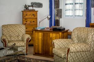 ein Wohnzimmer mit 2 Stühlen und einem Schreibtisch in der Unterkunft Maré Alta - Casa de Férias in Maia