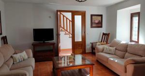 a living room with a couch and a tv at Antiguo Consistorio in San Martín de la Vega del Alberche