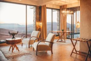 a room with chairs and tables and large windows at Diar illi in Touama