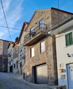a stone building with a garage in a street at Casa da Cantareira in Loriga