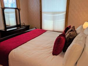 um quarto com uma grande cama branca com almofadas vermelhas em Sagebrush I - Cozy Downtown Home W-patio Dining em Fruita