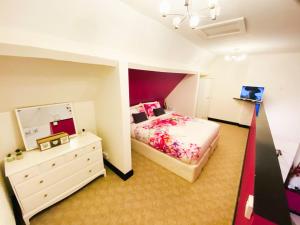 a bedroom with a bed and a dresser and a mirror at PHOENIX Apartments in Goole