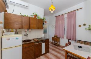 a kitchen with wooden cabinets and a white refrigerator at Apartment Jasenka in Brna