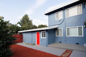 a blue house with a red door in a yard at Elegant place near Santana Row for vacation/work in San Jose