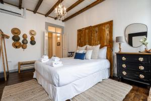 a bedroom with a large white bed and a mirror at Al Sharaz - Dazzling Cottage in Alentejo in Reguengos de Monsaraz