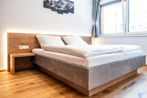 uma cama grande num quarto com uma janela em Apartment Griass di Fügen em Fügen