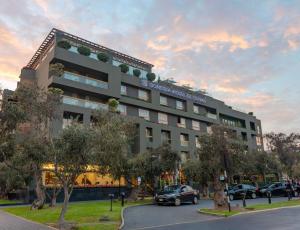 een gebouw waar auto's voor geparkeerd staan bij Sonesta Hotel El Olivar in Lima