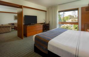 Uma TV ou centro de entretenimento em Sonesta Hotel El Olivar