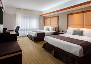 a hotel room with two beds and a television at Sonesta Hotel El Olivar in Lima