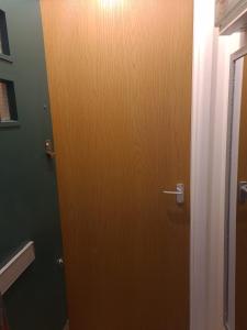 una puerta de madera en una habitación con una pared verde en Cosy Apartment, Peckham Rye en Londres