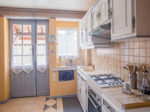 a kitchen with white cabinets and a stove top oven at Elegant holiday home near Les Eyzies de Tayac in Meyrals