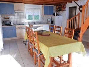 a kitchen with a table and some blue cabinets at Sunny holiday home with private garden in Le Haut-du-Them