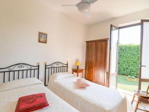 a bedroom with two beds and a large window at Belvilla by OYO Chiaraquattro in Acquaviva