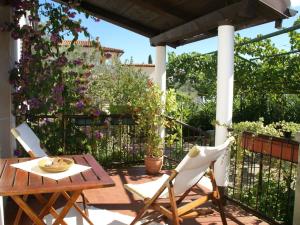 a patio with a table and chairs and a fence with flowers at Charming Holiday Home in Pula near Beach in Štinjan