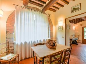 ein Esszimmer mit einem Tisch und einem großen Fenster in der Unterkunft Belvilla by OYO Il Fienile in Monterchi