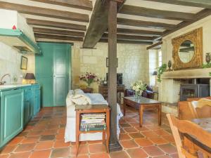 a kitchen with blue cabinets and a table at Former customs house with large garden and private pool 4 km from Chinon in La Roche-Clermault