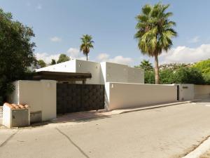 ベニッサにあるBelvilla by OYO La Vidaの塀と椰子の木のある家