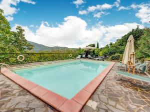 a swimming pool with an umbrella and a patio at Belvilla by OYO Welcoming Holiday Home with Pool in Monterchi