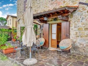 a umbrella sitting on a patio in front of a building at Belvilla by OYO Welcoming Holiday Home with Pool in Monterchi